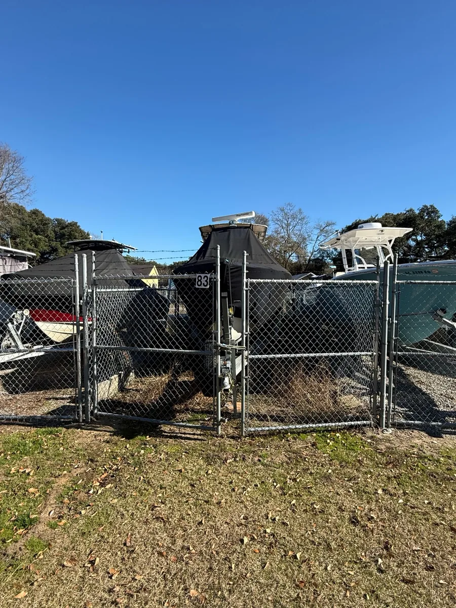 Covered boat and neighboring boats behind the gate of space 83