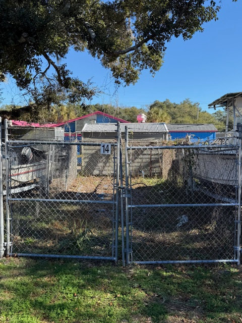 Gated boat storage space 14 beneath a shade tree